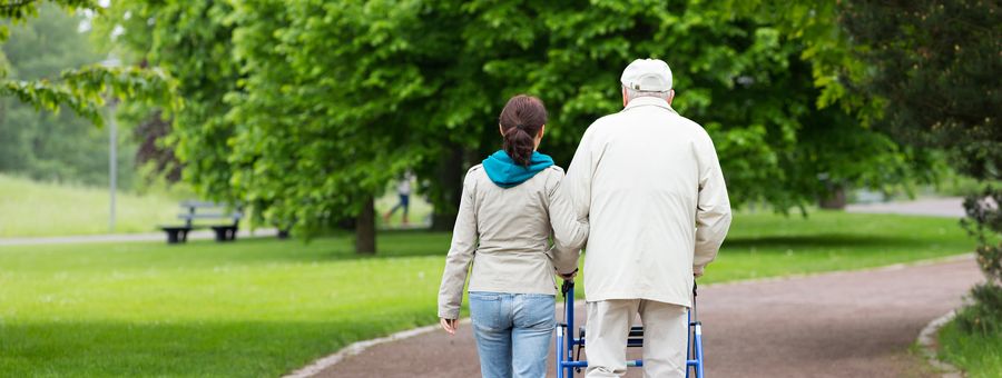Caregiver assisting a resident walking outdoors