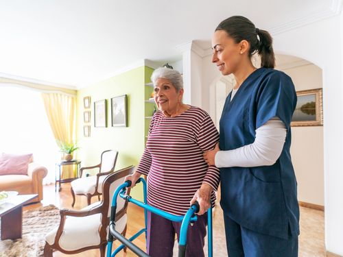Caregiver assisting a resident with a walker